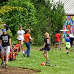 Adults and children participating in a green space clean-up event.