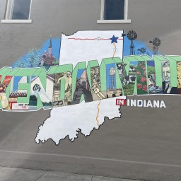 A brightly colored mural on a dark gray wall features the word "Kendallville," where each block letter depicts an image.