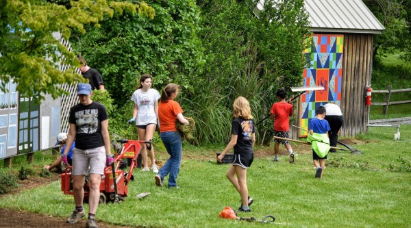 Adults and children participating in a green space clean-up event.
