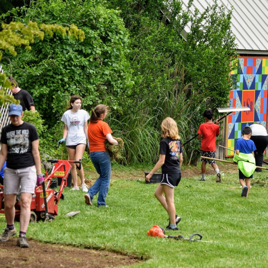 Adults and children participating in a green space clean-up event.