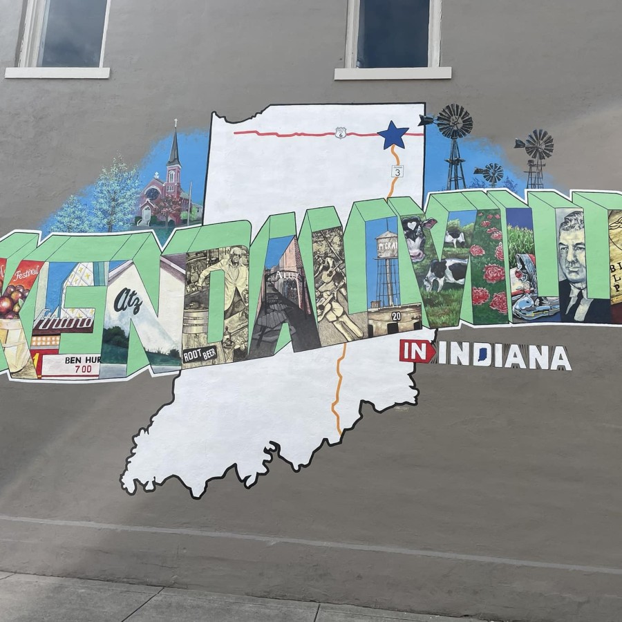 A brightly colored mural on a dark gray wall features the word "Kendallville," where each block letter depicts an image.