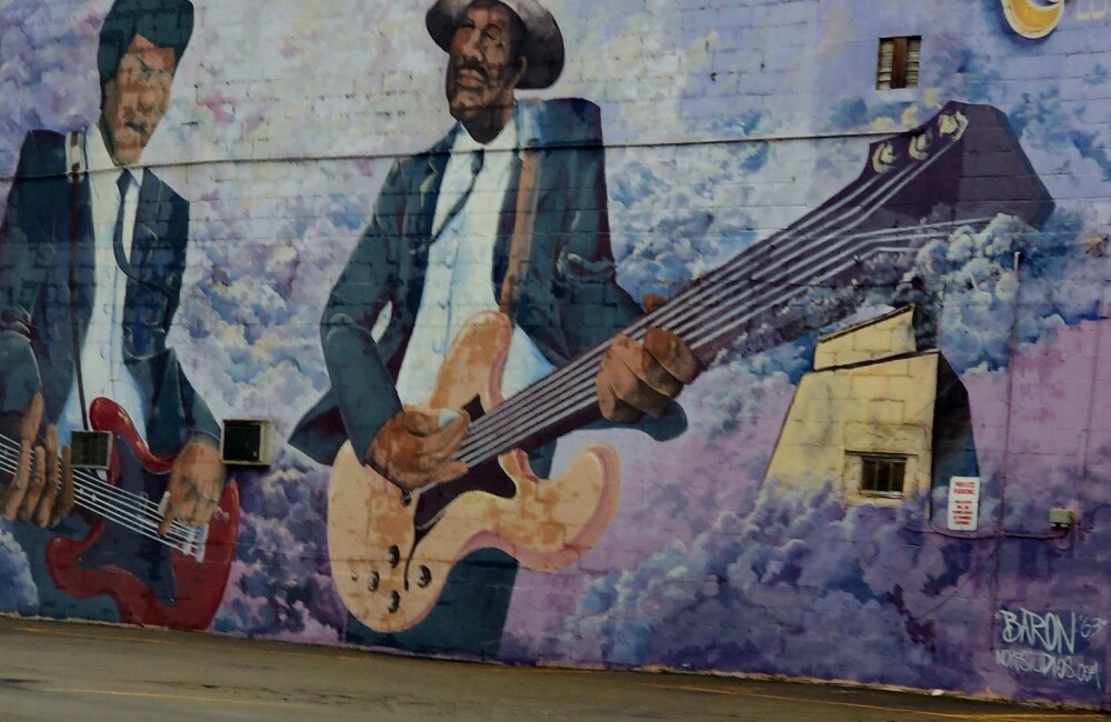 Photo of colorful mural on the side of a building depicting men playing guitars in Nashville, Tennessee.