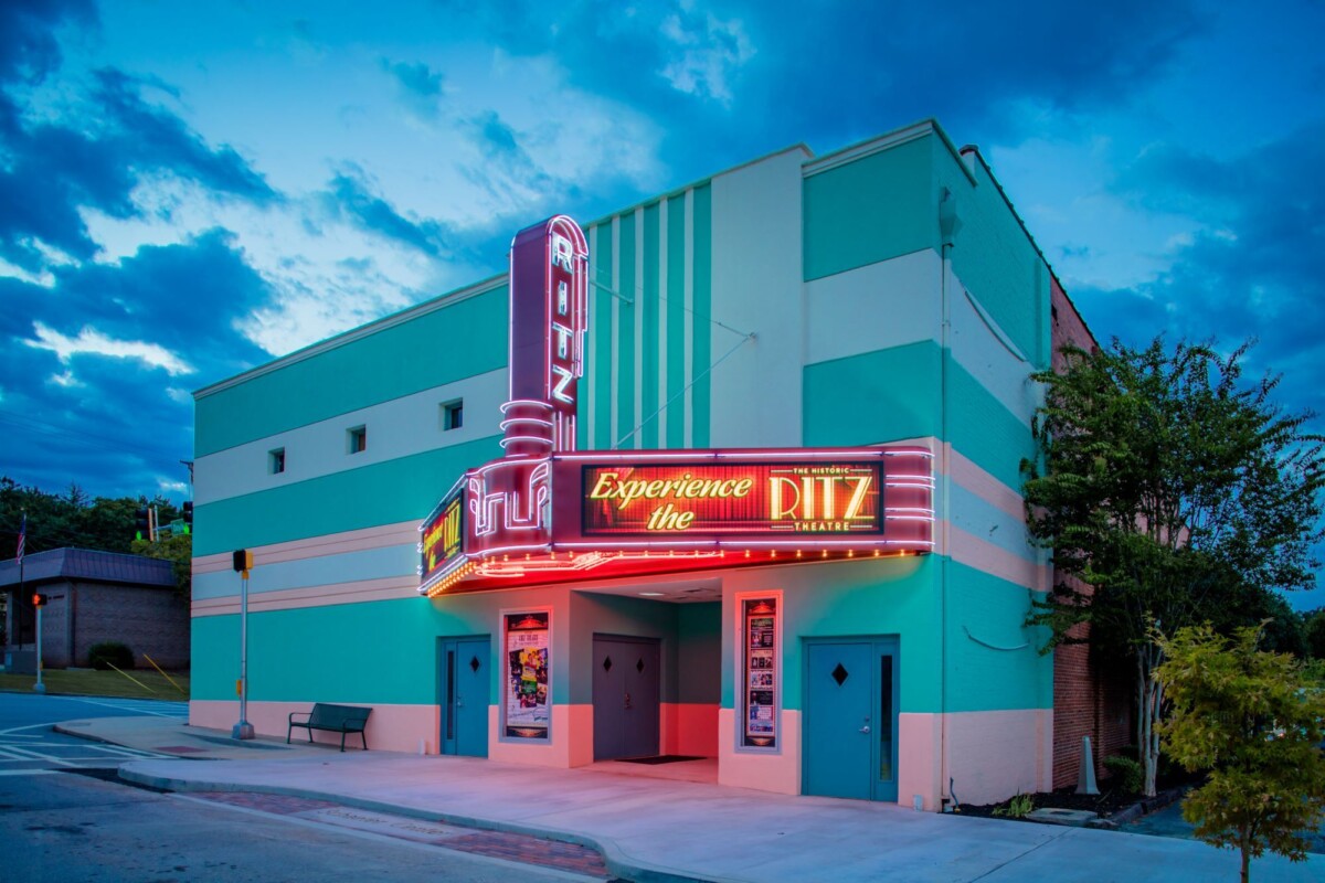 Seafoam green and turquoise facade with lit-up marquee of Historic Ritz Theater in Toccoa, Georgia
