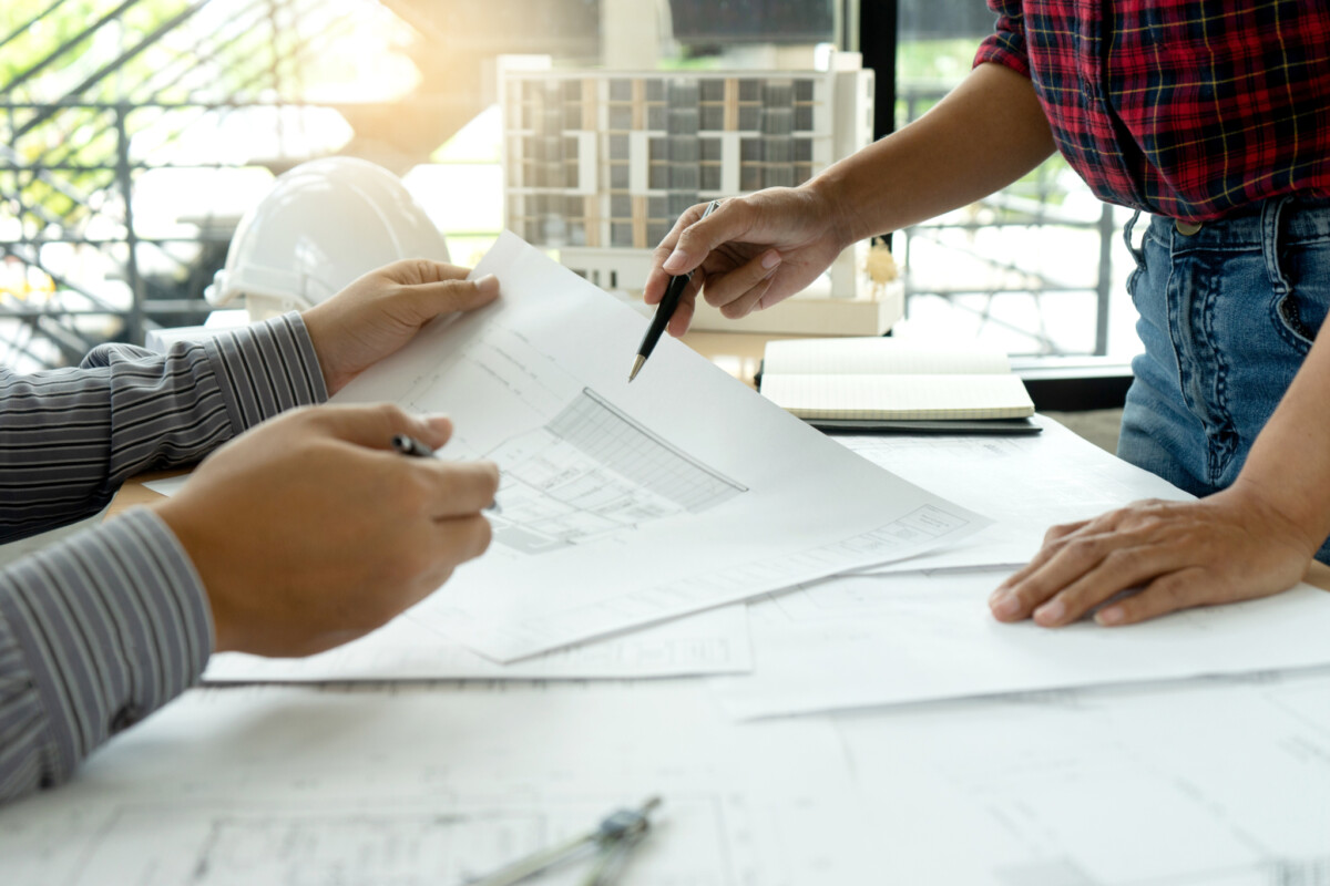 Two people look at architectural drawings