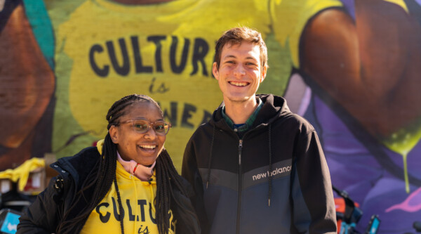 Una mujer y un hombre frente a un mural en el que se lee "La cultura es poder" en Chicago, Illinois.