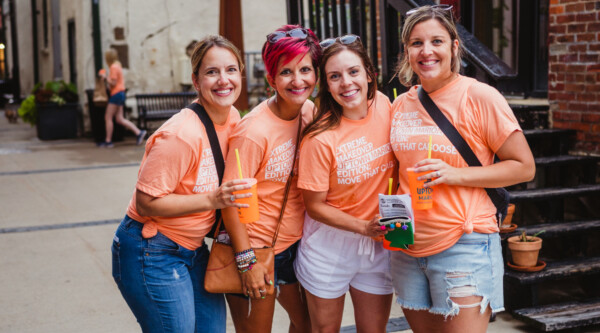 Tres mujeres con camisetas naranjas a juego en Marion, Iowa.