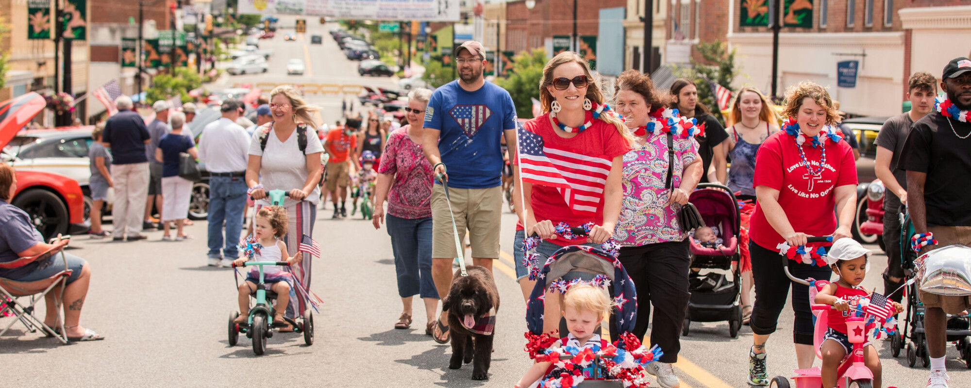 Grupos de familias vestidas con los colores patrióticos caminan por la calle principal del centro de Wytheville, Virginia.