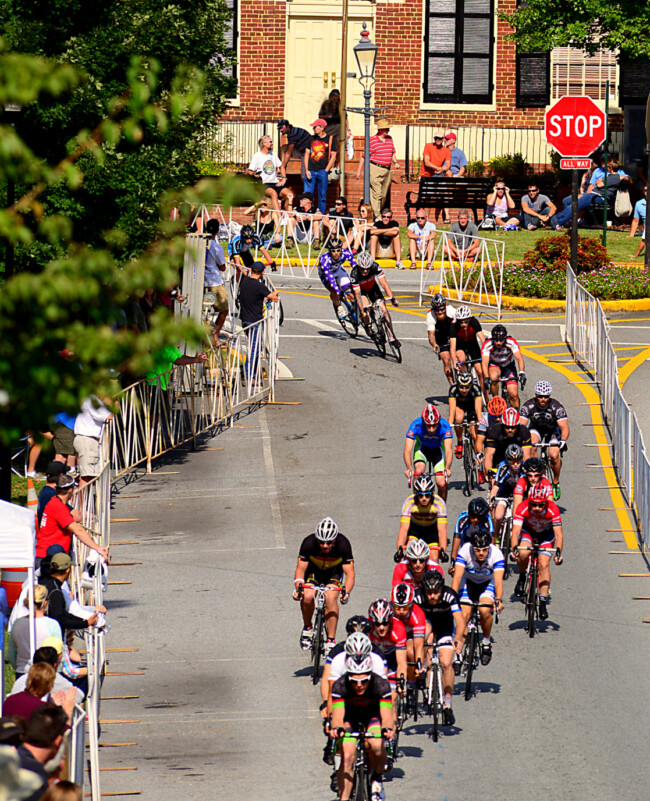 A cycling peloton moves down a street.