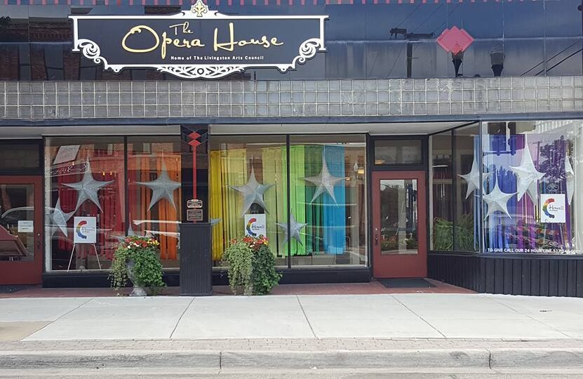 A rainbow colored window display on the ground floor of an opera house.