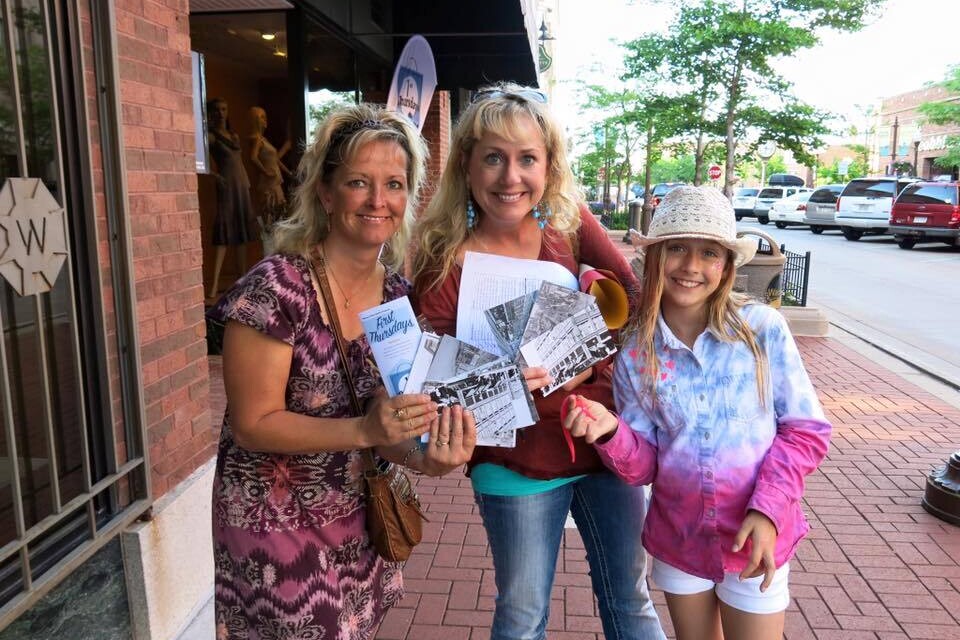 Two women and a girl holding pamphlets.