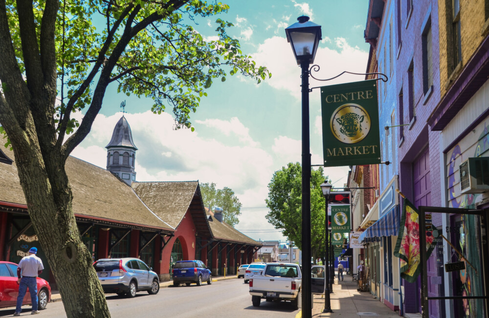 Downtown street lined with brightly colored historic buildings and street banners promoting the Centre Market.