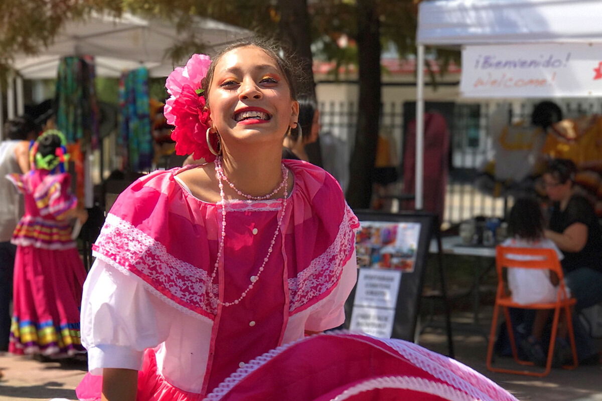 Ballet folklorico dancer swirls the skirt of her bright pink dress.