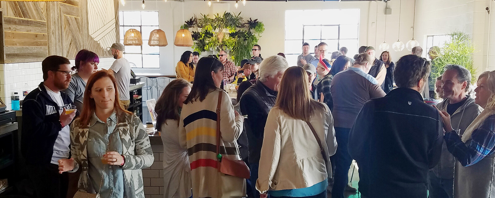 People gather inside the tap room of a brewery.