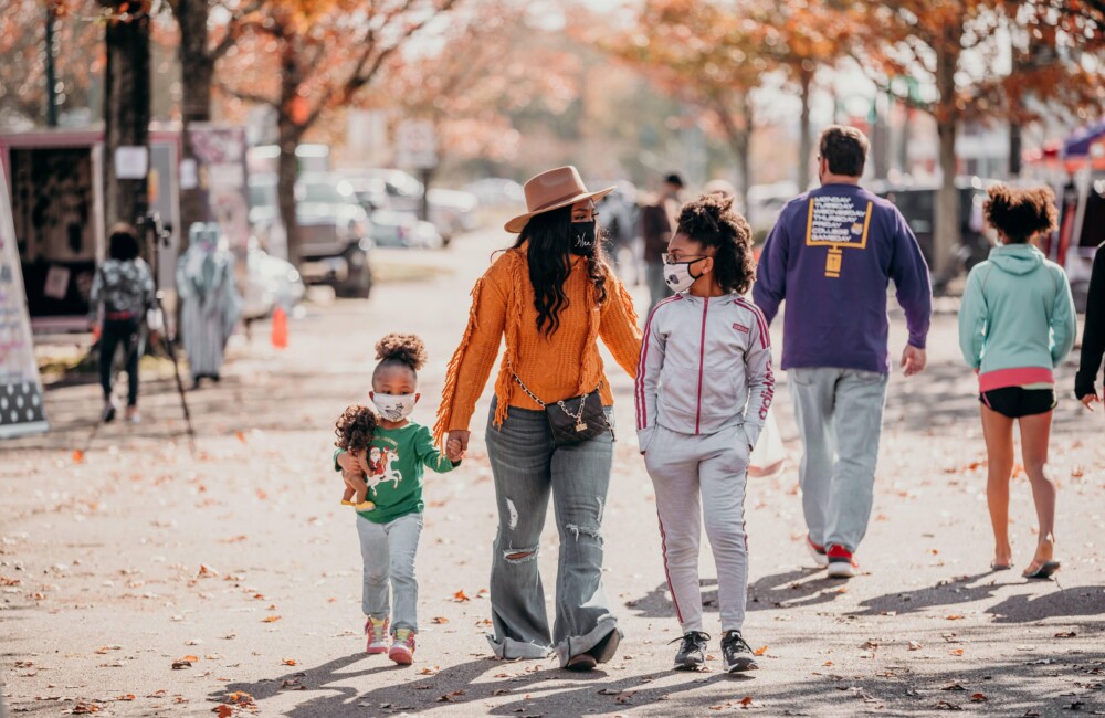 A family strolls through the outdoor pop-up holiday market event.