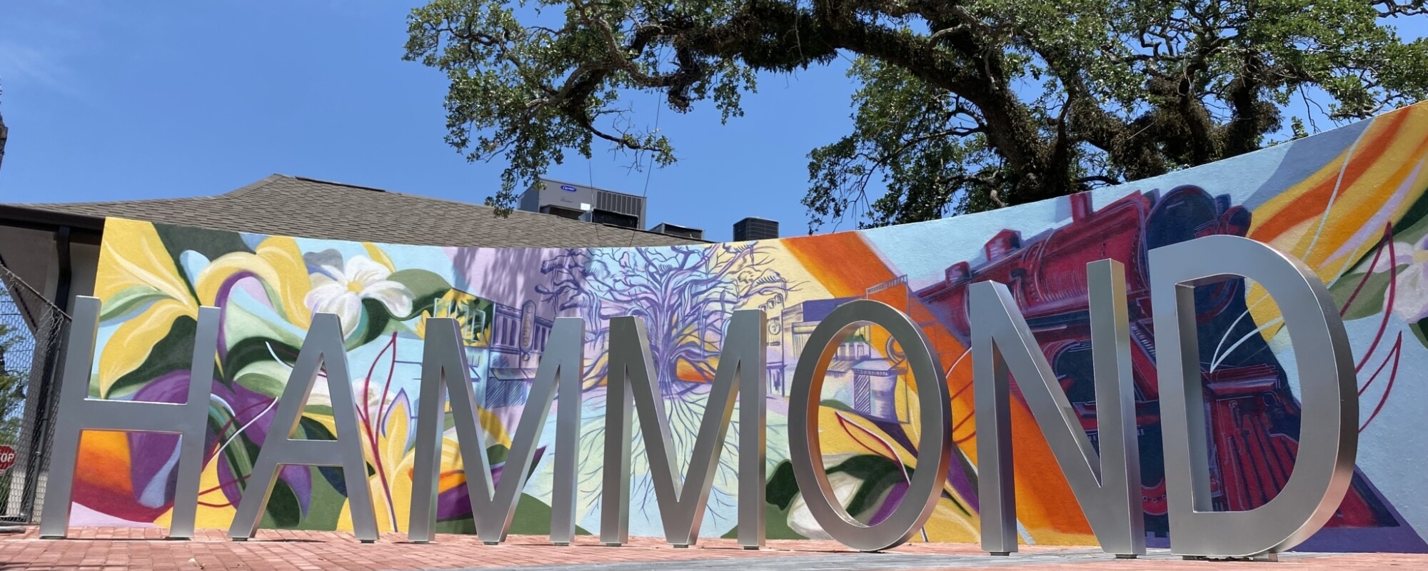Free-standing letters spell "HAMMOND" in front of a curved wall that is decorated with a brightly colored mural