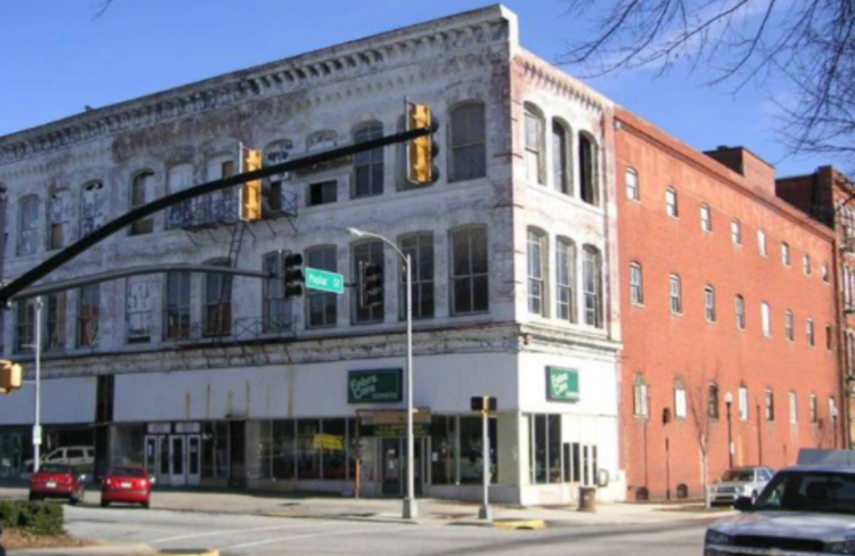 Exterior of a historic three-story building with a deteriorated facade.