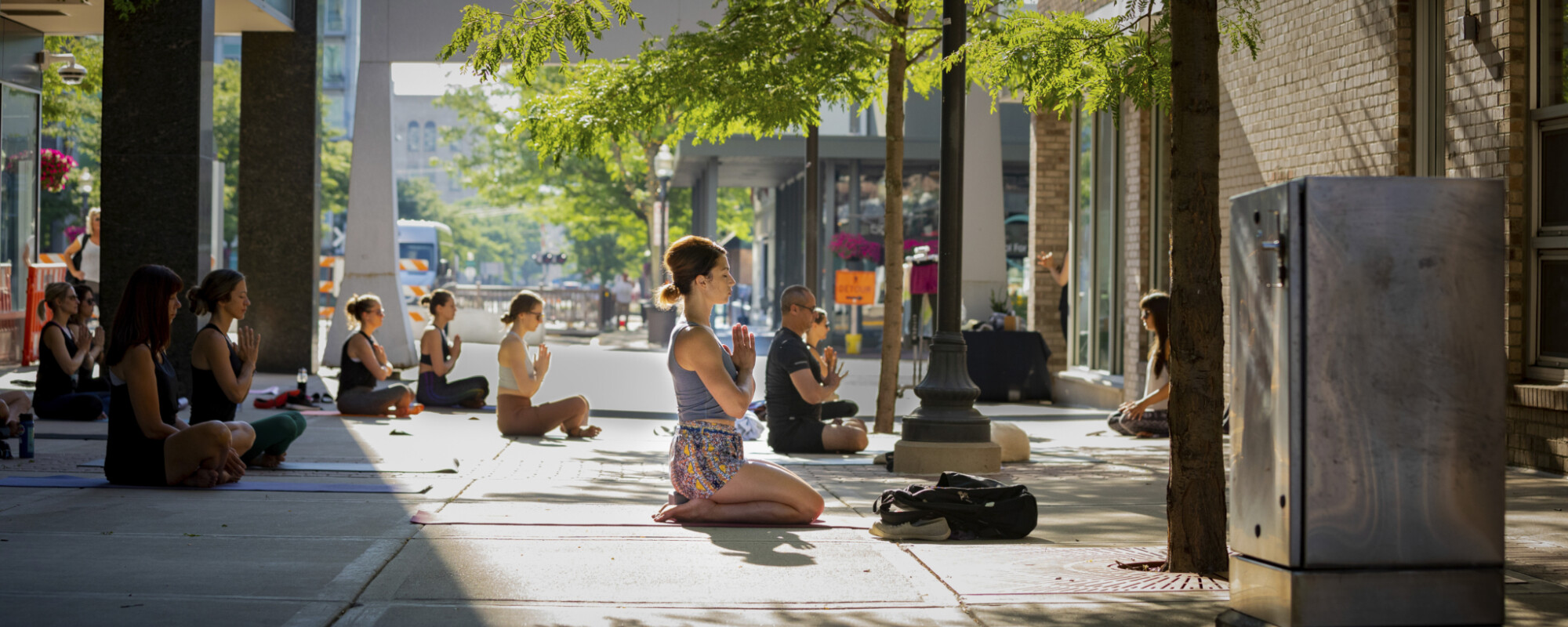 People practicing yoga in an outdoor plaza.