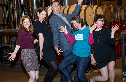 Five people hold silly poses for a group photo.