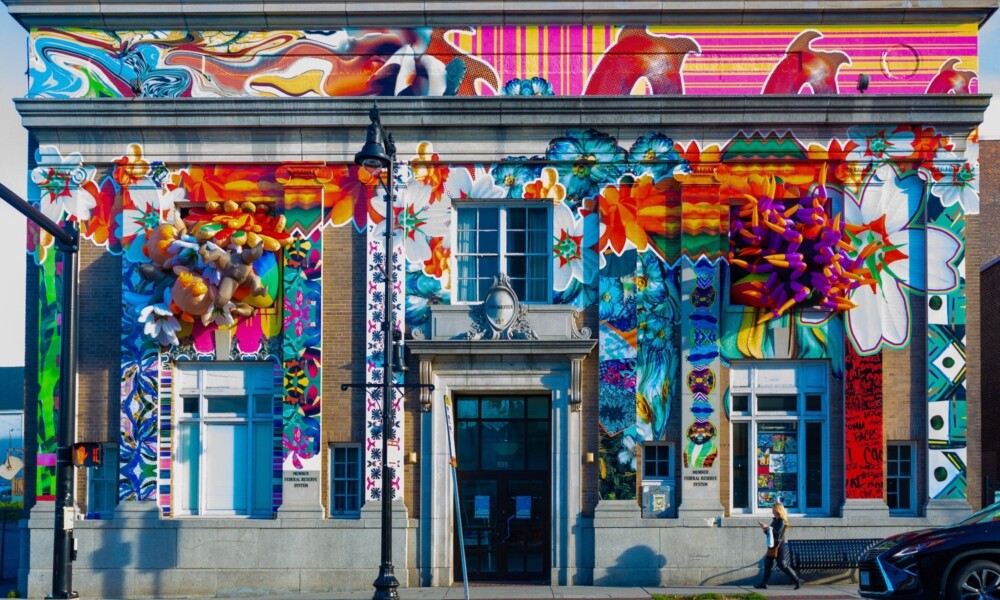 Historic bank building with a colorful art installation on the façade.