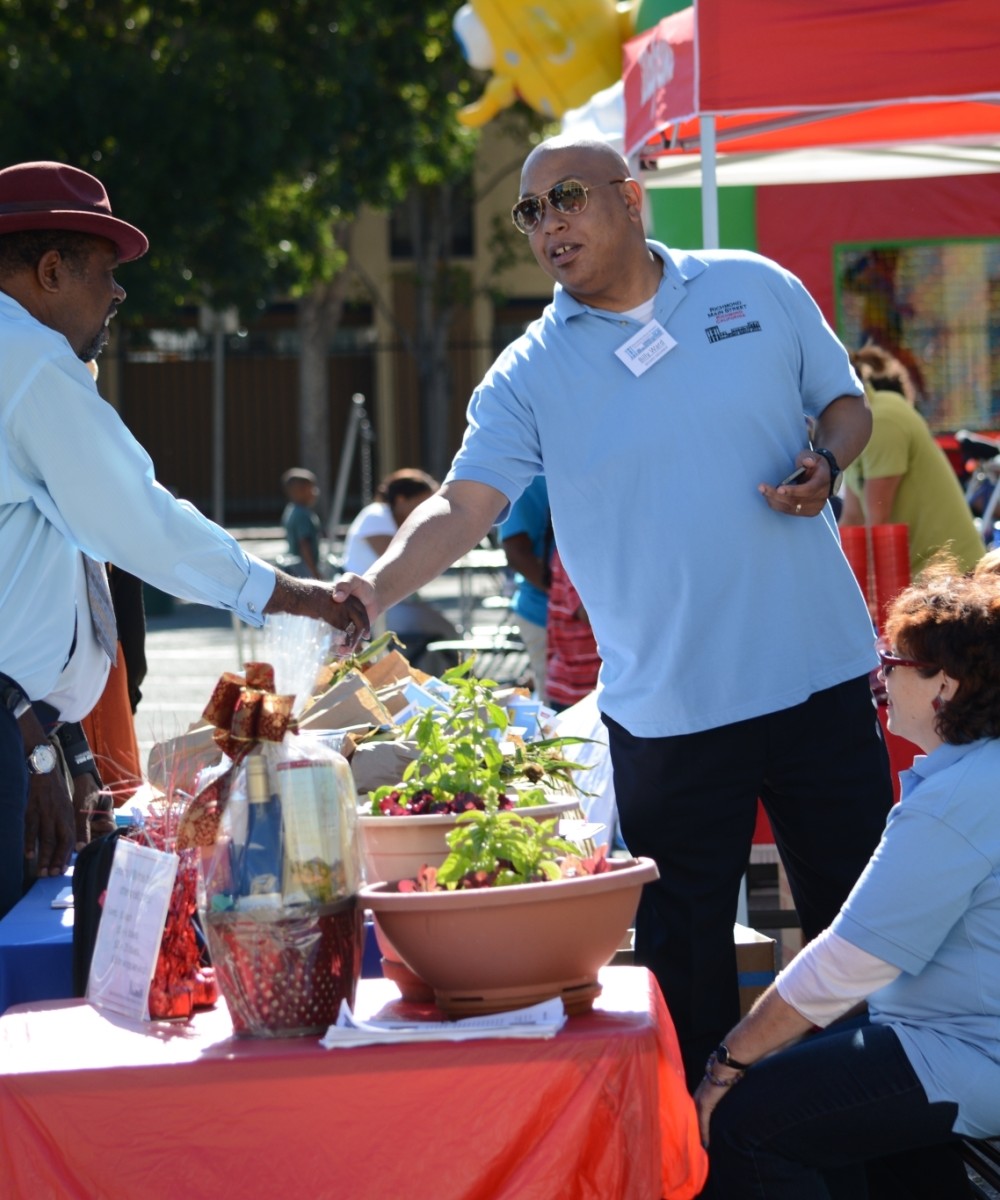 Men shaking hands at a community event.