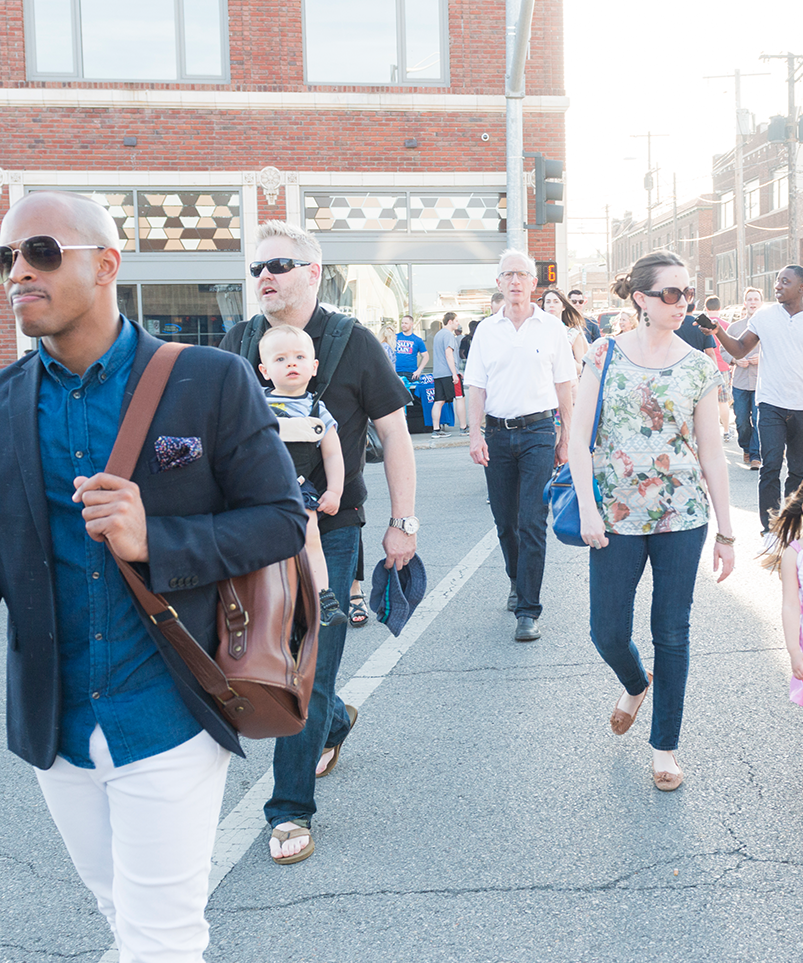 Group of people walking across a busy street.