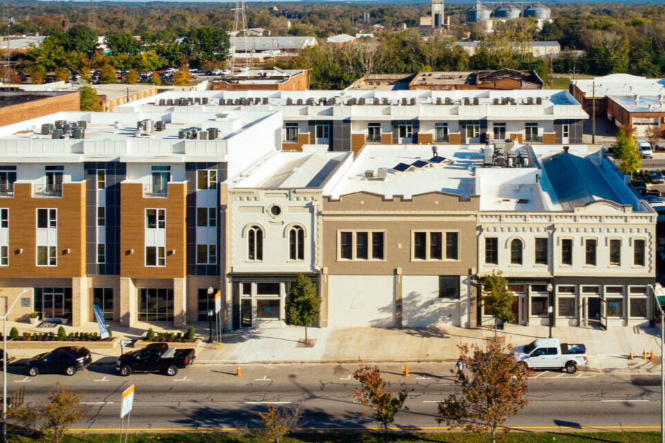 Aerial view of a street with commercial and upper story residential buildings.