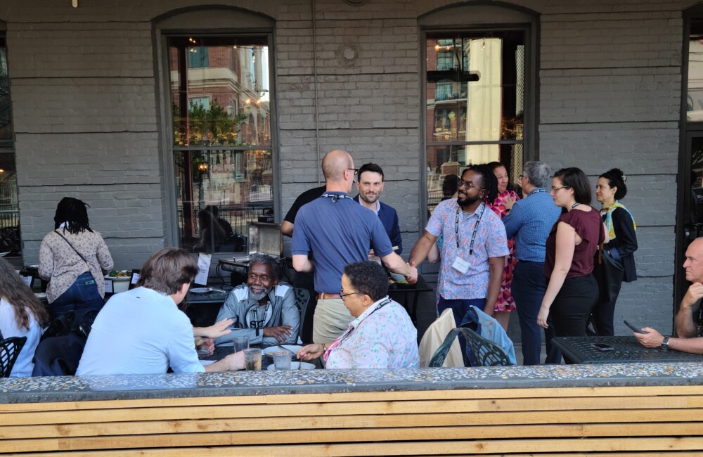 Two people shake hands at a mixer event.