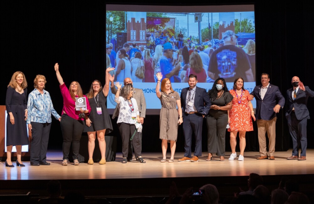 A team of colleagues receive an award on stage.