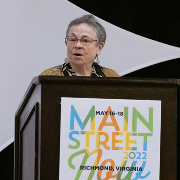 A woman speaks from behind a podium.