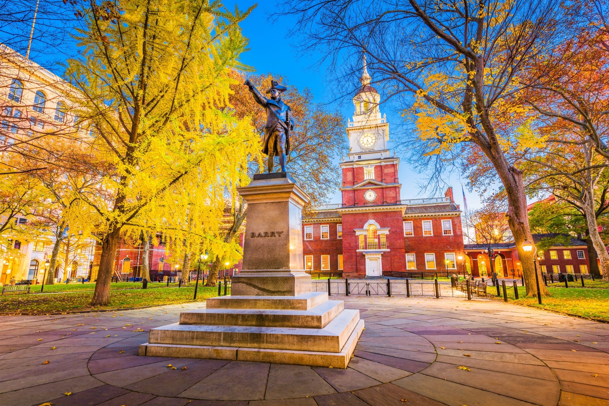 Bronze statue on a tall pedestal with Independence Hall in the background.