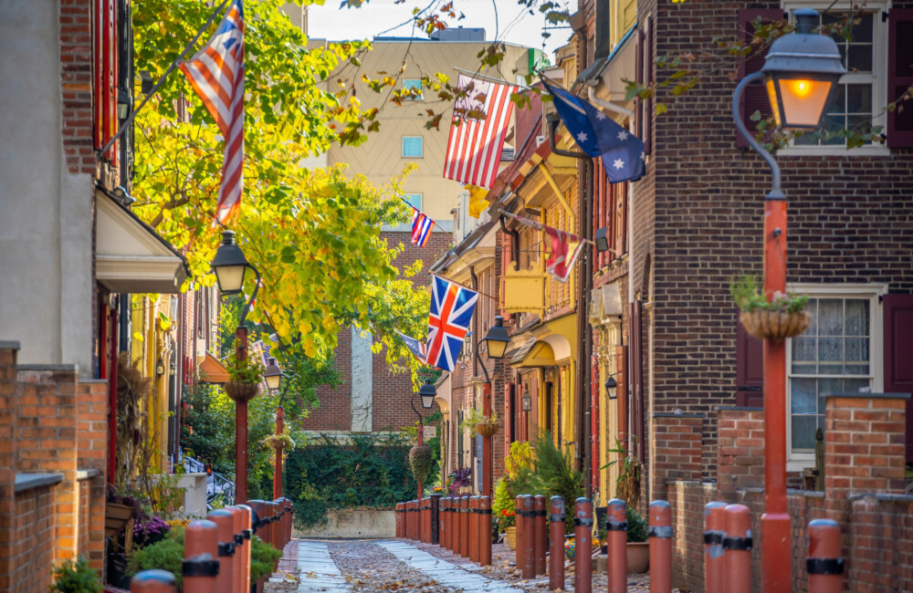 A narrow street lined with historic brick buildings and antique streetlamps.