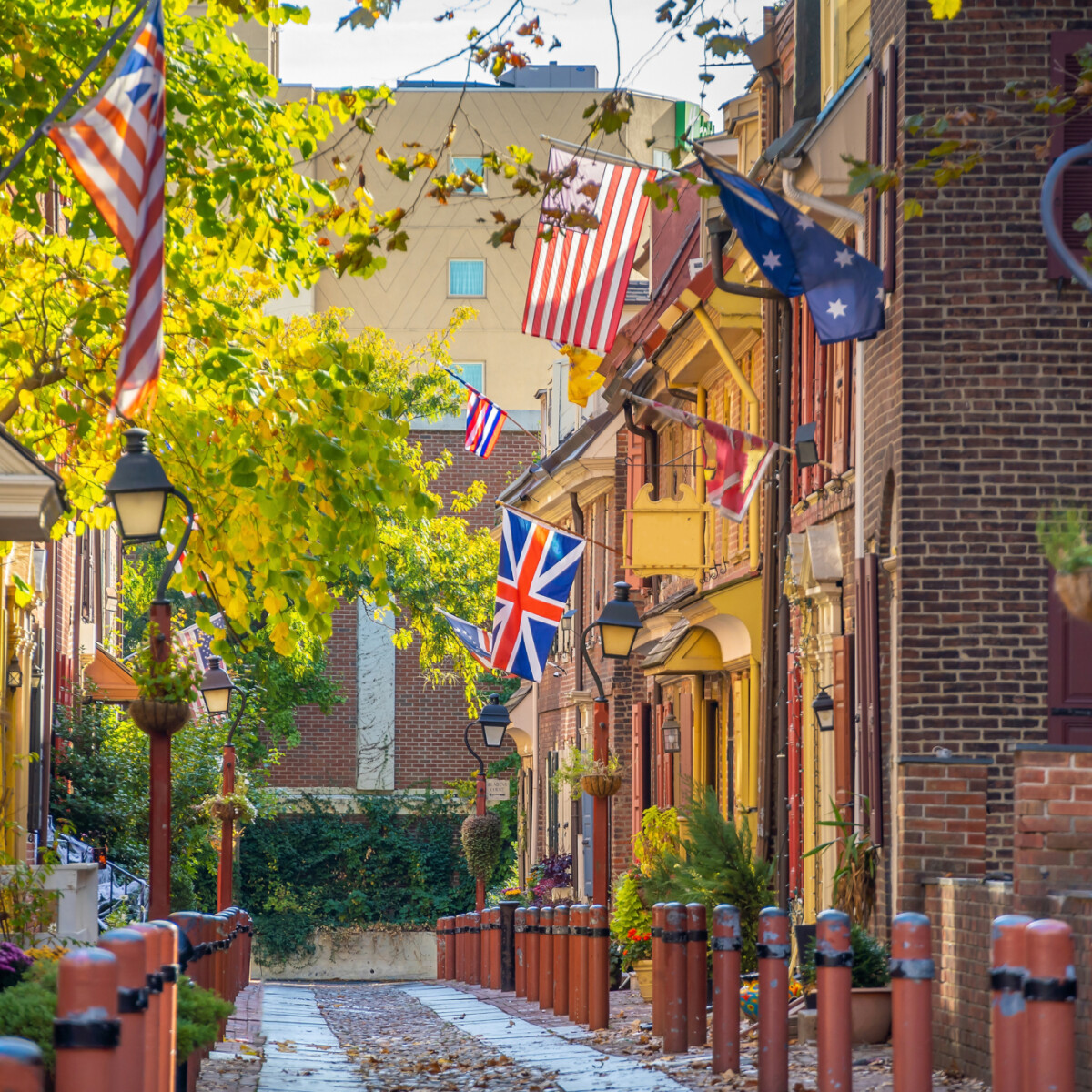 A narrow street lined with historic brick buildings and antique streetlamps.