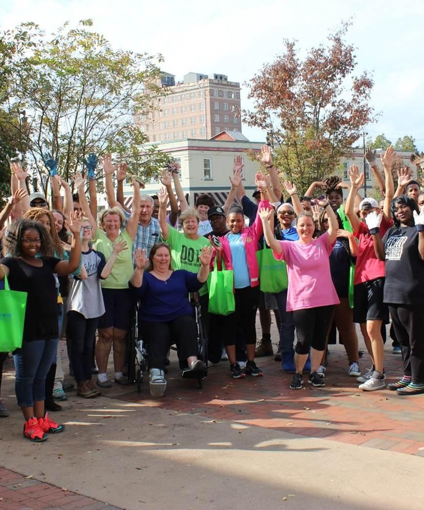 A group of volunteers holding their hands up in celebration