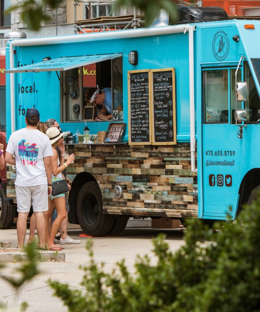 People waiting in line in front of a blue food truck