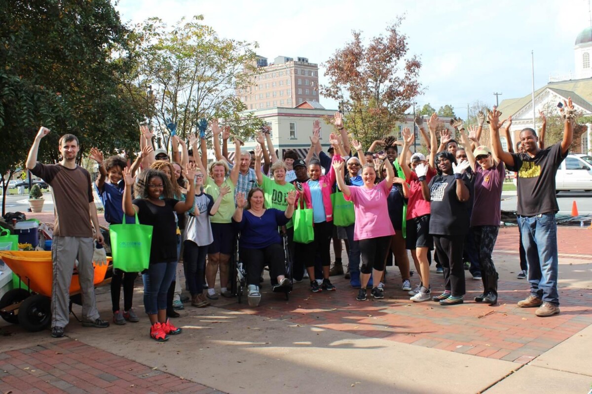 A group of volunteers holding their hands up in celebration