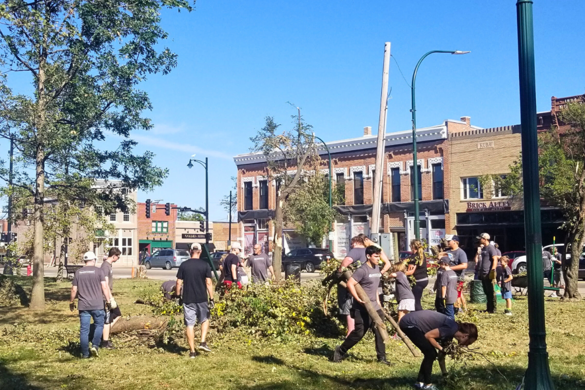 Volunteers in a downtown park cleaning up fallen tree limbs and other debris