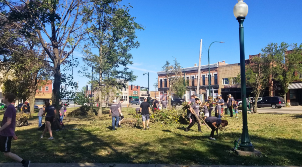 Voluntarios en un parque del centro de la ciudad limpiando ramas de árboles caídas y otros desechos.