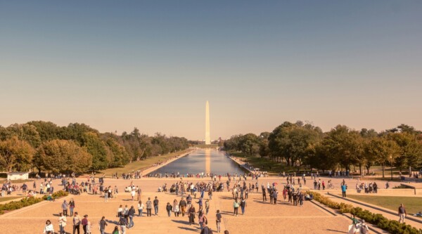 Gente paseando por el centro comercial nacional con el monumento a Washington al fondo