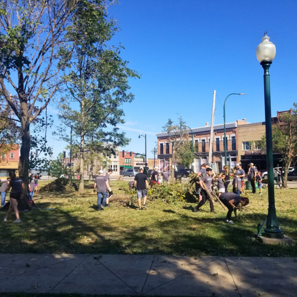 Volunteers in a downtown park cleaning up fallen tree limbs and other debris