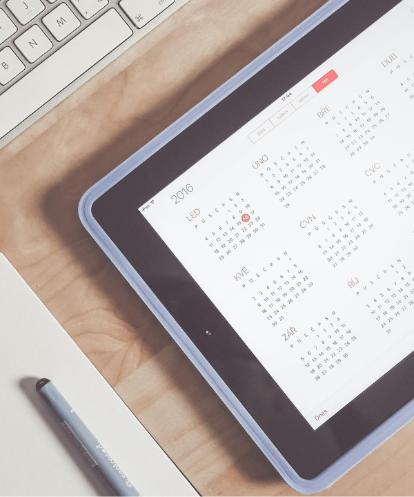 Notebook, keyboard, and iPad with calendar pulled up.