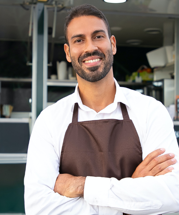 Man wearing apron standing outside of food truck