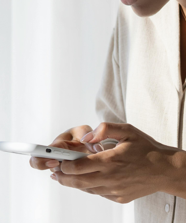 A woman holds a phone with both hands.