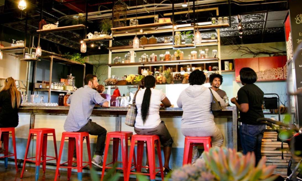 Foto de 5 personas sentadas en un bar charlando con el camarero