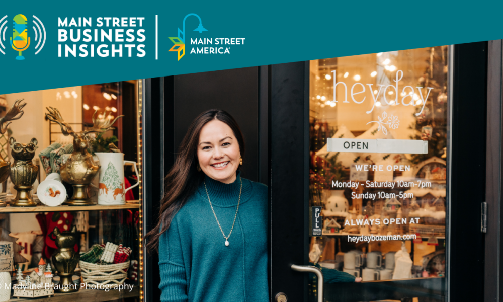 A woman wearing an emerald green sweater smiles while opening door to small boutique.