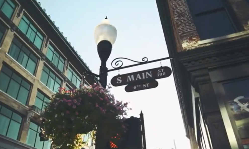 A street sign reading "main street" on a lamp post with a flower box