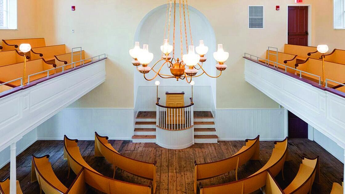 View from the balcony of the African American Meeting House in Boston, Massachusetts showing wood pews facing a front podium.