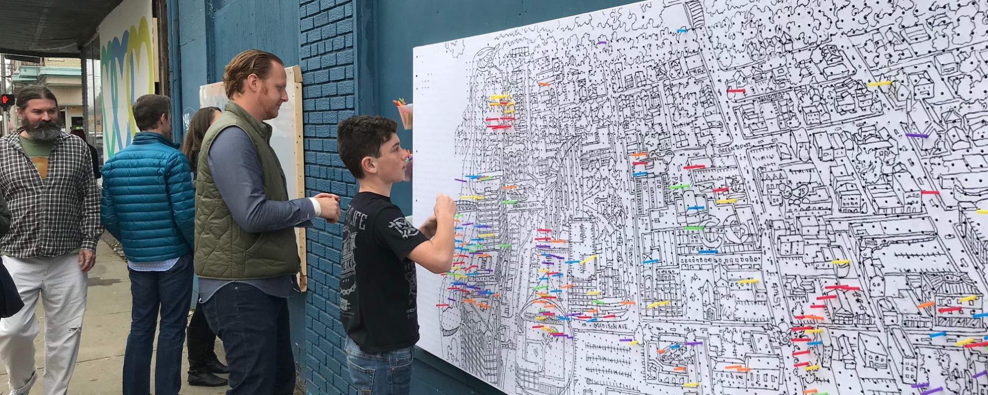 People add post-it notes to a large map of downtown Covington, KY.