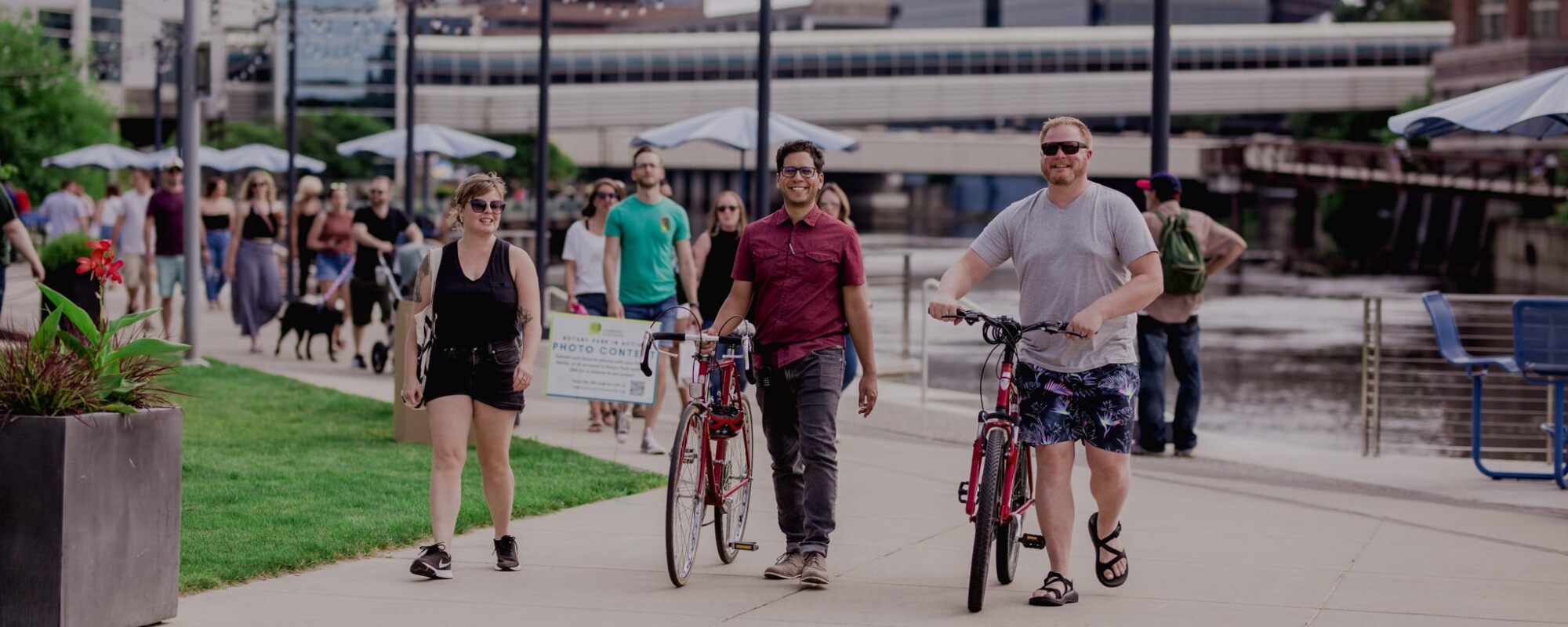 People walking with bikes on a pedestrian/bike path in Lansing, Michigan.