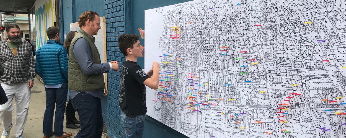 People participating in a downtown mapping exercise by putting pins in a large map