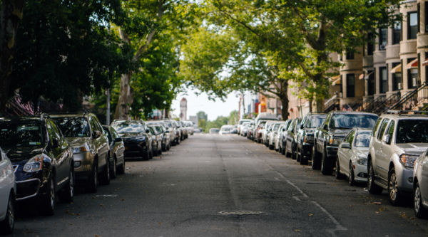Cars parked on either side of a tree-lined street in a historic neighborhood